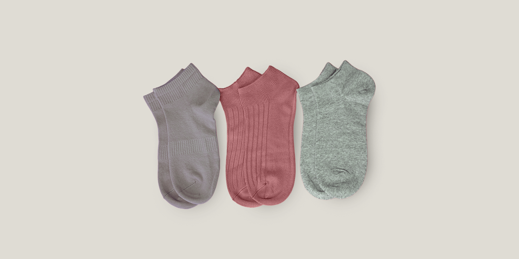 Banner für die Kategorie „Damen Socken Sets“ im Boxxers Online Shop. Drei Paar kurze Damensocken in Grau, Altrosa und Hellgrau liegen nebeneinander vor einem hellbeigen Hintergrund.